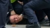Полицаи притискат и арестуват протестиращ по време на демонстрация в Шанхай, Китай, неделя, 27 ноември 2022 г.