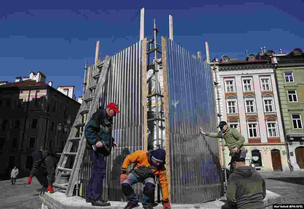 Volunteers erect a frame around a monument in Lviv. &nbsp; Barriers such as this are intended to shelter monuments inside from shockwaves, which could topple statues without the physical impact of shrapnel, or debris from an explosion. &nbsp; &nbsp;