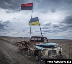 Украинският флаг и знамето на Украинската въстаническа армия (горе), заснети близо до фронтовата линия между украинските сили и проруските сепаратисти през 2019 г.
