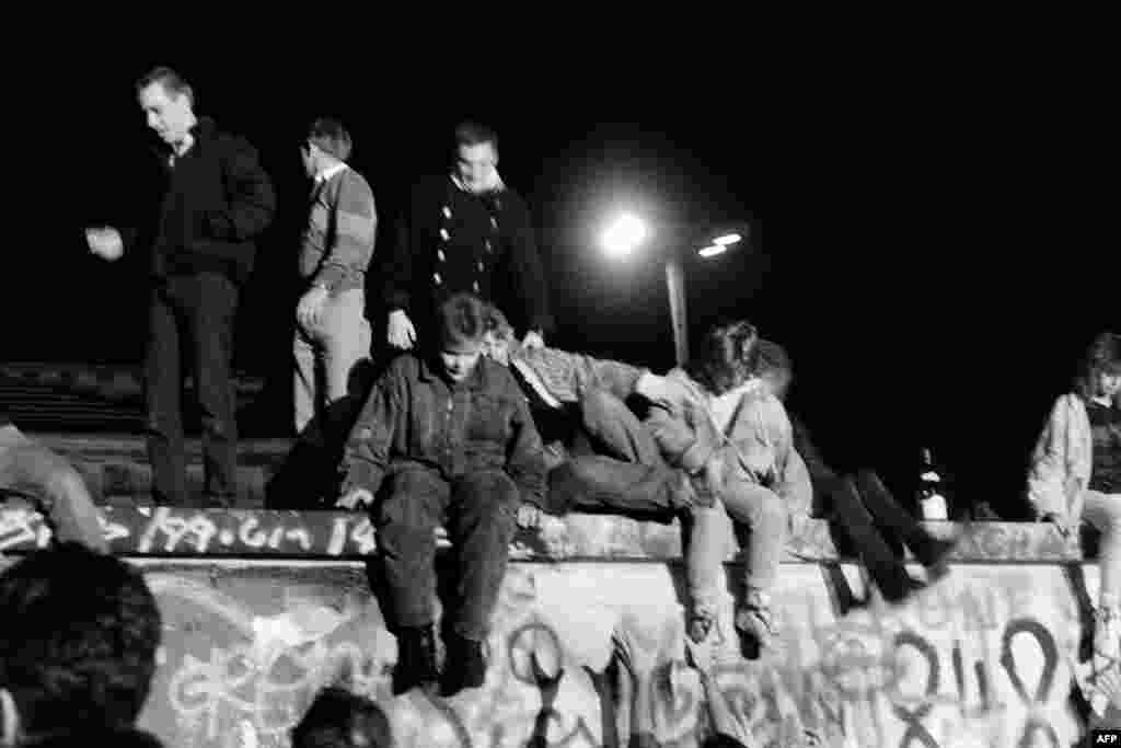 Граждани на Западен Берлин са се качили на стената на 9 ноември 1989 г.&nbsp; По-рано същата вечер&nbsp;секретарят по въпросите на информацията на Германската социалистическа партия Гюнтер Шабовски импровизирано произнея една дума, която не е била написана в листа му, подаден от председателя на управляващата партия Егон Кренц. Източногерманското правителство започва да обявява, че вдига забраната за пътуване извън ГДР. Намерението е новините за премахването на ограниченията за пътуване да бъдат съобщавани на части, но когато Шабовски е попитан от журналиста от германския вестник &bdquo;Билд&ldquo; Петер Брикман кога влизат в сила промените, Шабовски отговаря: &quot;Незабавно&quot;.