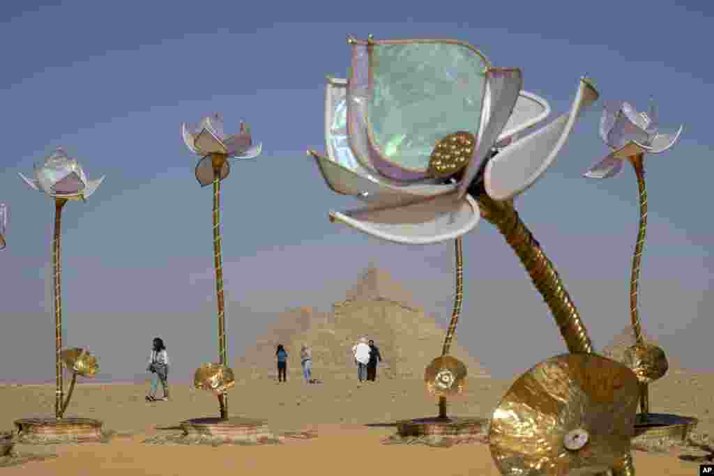 Vizitorët kalojnë pranë veprës së artit &quot;Pulse and Bloom&quot; të artistit indian Shilo Shiv Suleman gjatë ekspozitës së artit bashkëkohor &quot;Forever Is Now&quot; në vendin historik te Piramidat e Gizës, në periferi të Kajros, Egjipt, të enjten, 24 tetor.