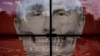 Oamenii trec pe lângă o reprezentare artistică a președintelui rus Vladimir Putin, în fața ambasadei Rusiei la București, România, vineri, 29 aprilie 2022. (AP Photo/Vadim Ghirda)