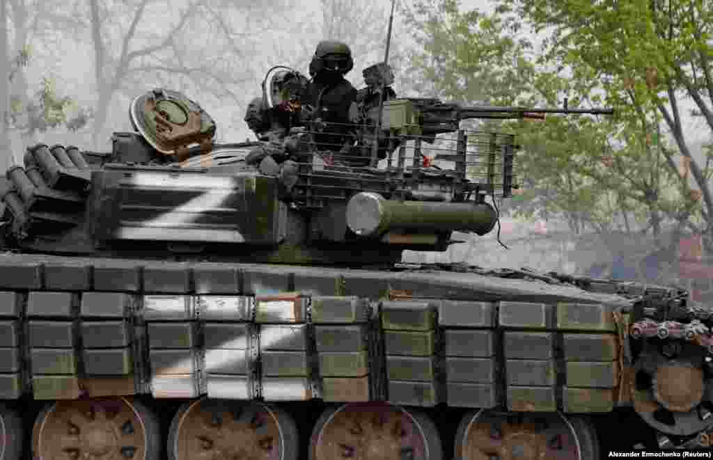 A Kreml által támogatott szakadár fegyveres egy tank tetején Mariupolban május 5-én. Putyin április 21-én győzelmet hirdetett Mariupol felett, és arra utasította az orosz csapatokat, hogy zárják körbe az üzemet, de ne merészkedjenek be