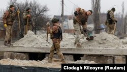 Ukrán katonák bunkert építenek Bahmutban december 26-án az intenzív ágyúzás közepette
