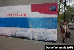 Putyin-graffiti 2.0: néhány hónappal később orosz ellenzéki színekre festették át a Putyin-falfestményt, rajta két felirattal: „Nem a háborúra” és „Add vissza az anyámat!” Belgrád, 2022. december 6.