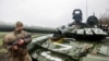 Український військовий біля пошкодженого російського танка Т-72БЗ, Донецька область, 13 квітня 2022 року