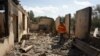 Pompierii printre ruinele unei case lovită de un bombardament azer în timpul recentelor confruntări la granița cu Azerbaidjanul, în așezarea Sotk, Armenia, 14 septembrie 2022