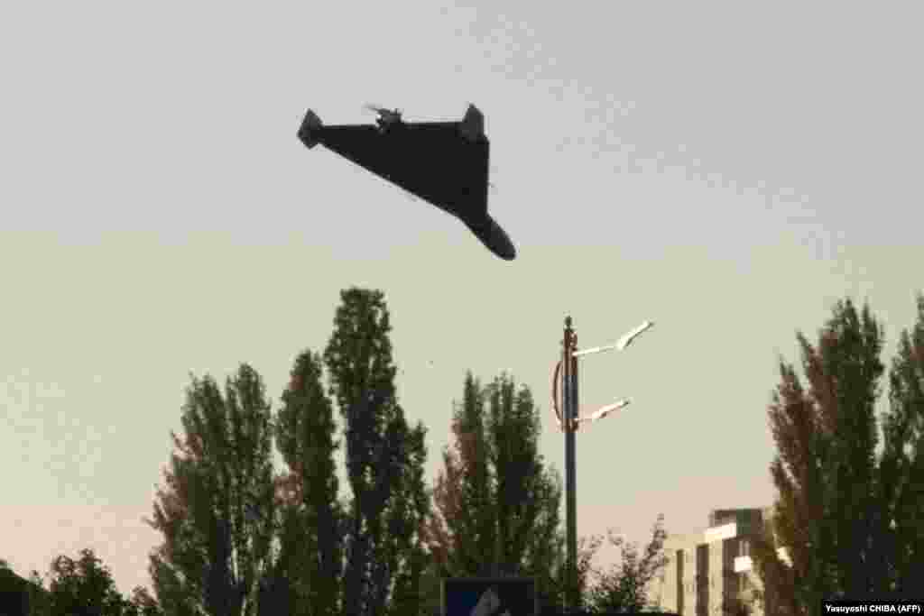 Un fotograf AFP a surprins la Kiev, pe 17 octombrie, cu puțin timp înainte de impact, o dronă sinucigașă lansată de Rusia și construită în Iran. Drona Shahed 136 de fabricație iraniană, pe care Rusia a redenumit-o Geran-2, conține o încărcătură explozivă și poate staționa deasupra țintelor înainte de a se prăbuși peste ele. Aripa lor triunghiulară le face ușor de identificat.&nbsp;