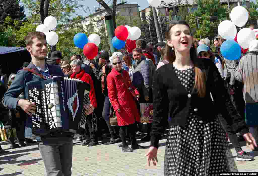Мала толпа гледа како изведувачи приредуваат шоу.