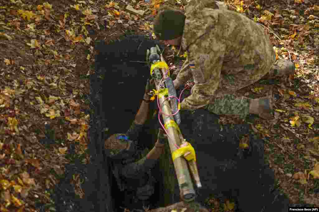 Украински војници ставаат руско оружје и муниција во длабока дупка што треба да биде уништена како дел од тековното чистење на областите што ги вратија украинските сили во регионот Харкив.&nbsp;