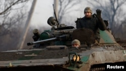 A Ukrainian serviceman waves from a tank during intense shelling on Christmas Day at the front line in Bakhmut. 
