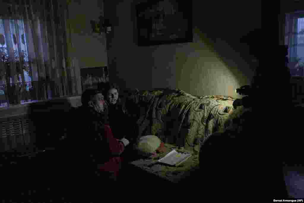Camera în care paramedicul tratează o fetiță în urma bombardamentelor rusești din 22 noiembrie este luminată cu o lanternă.