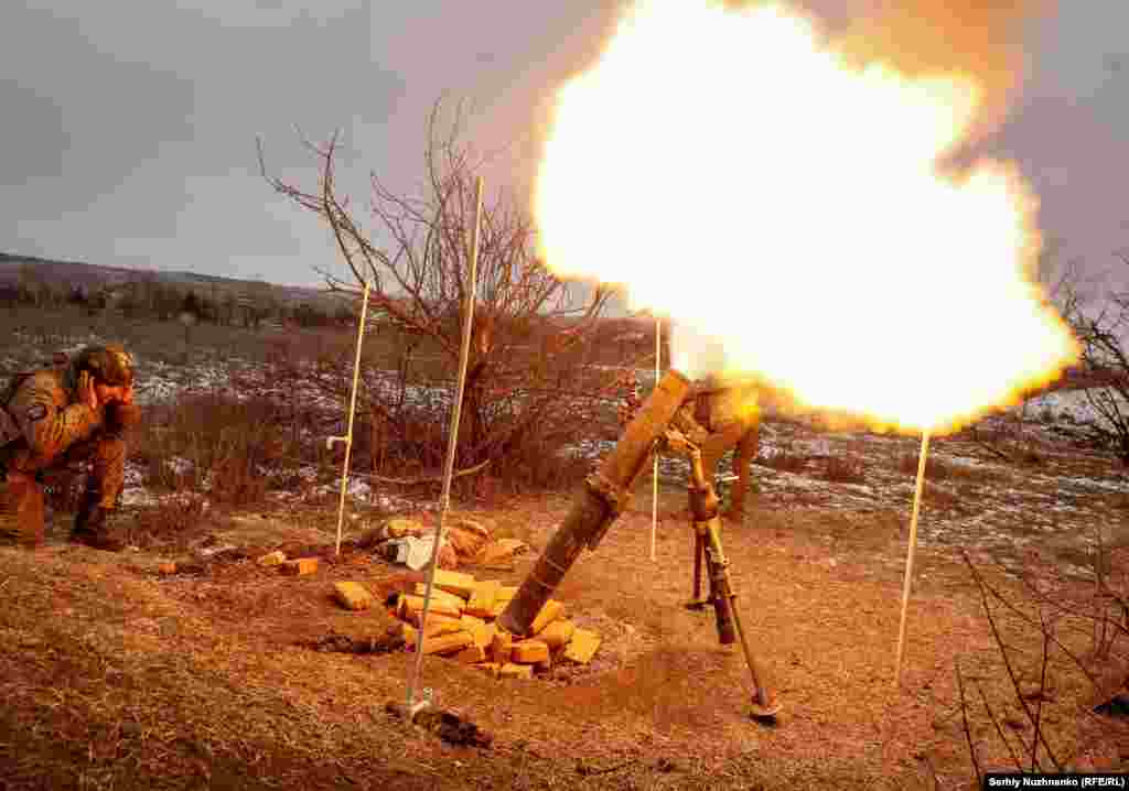 Militar ucrainean trăgând o salvă de mortiere contra pozițiilor rusești din apropiere de Soledar pe 14 ianuarie. Pe 10 ianuarie, mercenarii din grupul rusesc Vagner au pretins că au dobândit controlul asupra orașului Soledar, deși luptele grele continuă în și în jurul acestui oraș minier din Ucraina &nbsp;