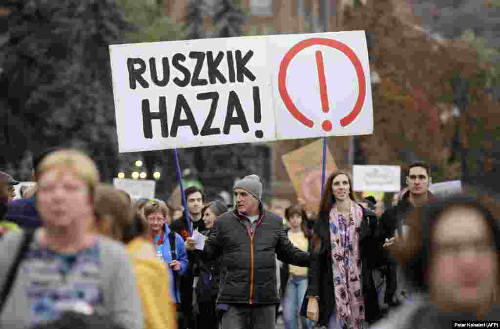 Протестиращ в антиправителственото шествие държи табела с надпис &bdquo;Руснаци, вървете си у дома&ldquo;. Фразата е широко възприета от унгарците по време на въстанието от 1956 г., което в крайна сметка е потушено от Москва.
