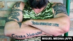 Soldat ucrainean pe frontul de est, pe brațe și-a tuatuat „Slavă Ucrainei” și „Ucraina începe cu tine”, 9 iulie 2022. 
