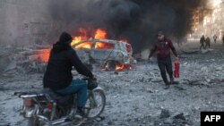 Ljudi pokušavaju ugasiti požare nakon zračnog napada 2. decembra na sirijski grad Idlib na sjeveru koji drže pobunjenici. Otkako se Rusija umiješala u građanski rat u Siriji, njeni zračni napadi igrali su ključnu podršku snagama sirijskog predsjednika Bashara al-Assada .