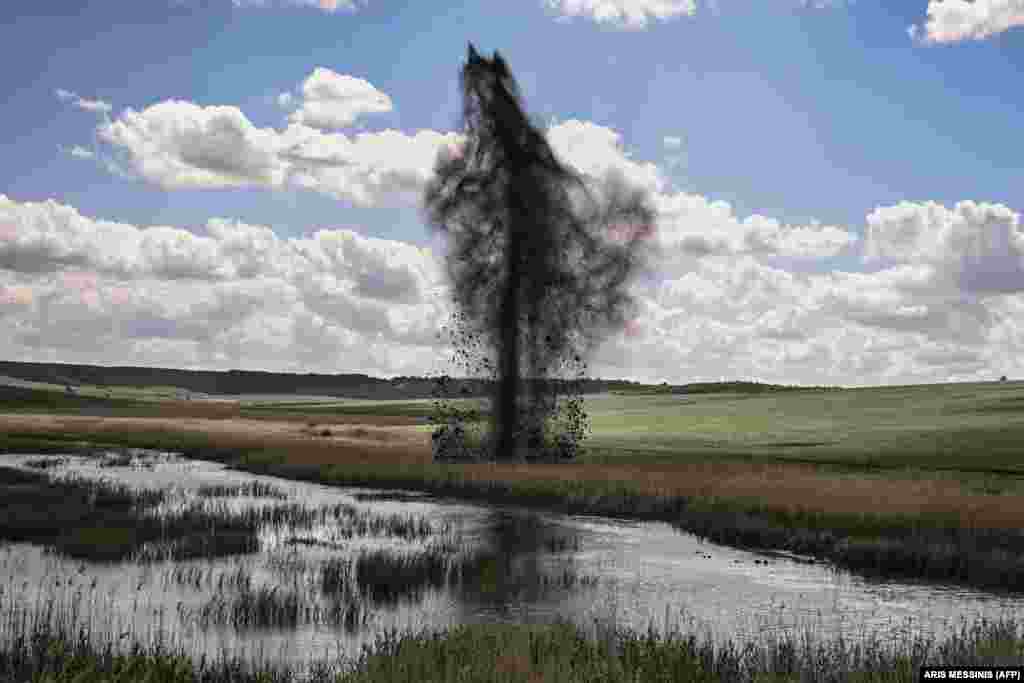 A mortar explodes beside the road to Lysychansk.