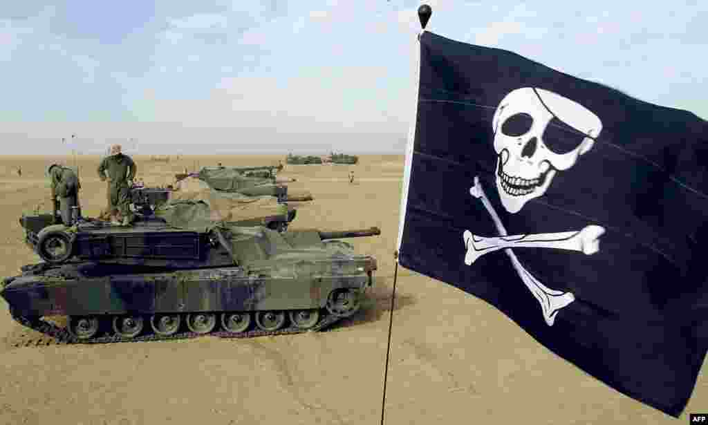 Резервисти на американскиот марински корпус го веат својот „Jolly Roger“ на тенк M1A1 Абрамс во кампот Гризли на американскиот маринци во Кувајт на 16 февруари 2003 година. Абрамс помина низ различни надградби, што резултираше со верзиите M1, M1A1 и M1A2, при што секоја има подобрувања во вооружувањето, заштитата и електрониката. 
