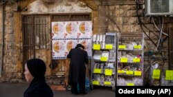 Egy ultraortodox zsidó férfi eldobható edényeket vásárol Jeruzsálem Mea Searim negyedében. Izrael új kormánya épp az egyszer használatos műanyagokra kivetett új adót akarja hatályon kívül helyezni. Az ultraortodox zsidók szerint az adó igazságtalanul őket célozta meg