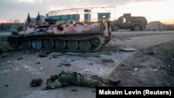 Тялото на войник без обозначителни знаци, за когото украинската армия твърди, че е руски, лежи на пътя към Харкив (Харков). 24 февруари 2022.