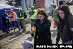 Egy ukrán menekült nő sírva lépi át a szlovák határt 2022 márciusában