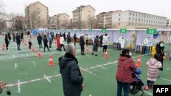 Жителите чекаат ред за да се тестираат за Ковид-19 во северниот кинески град Тијанџин. 12 јануари 2022 година.