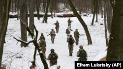 Членове на доброволен военен отряд към украинските въоръжени сили провеждат обучение в парк в Киев, 22 януари 2022.