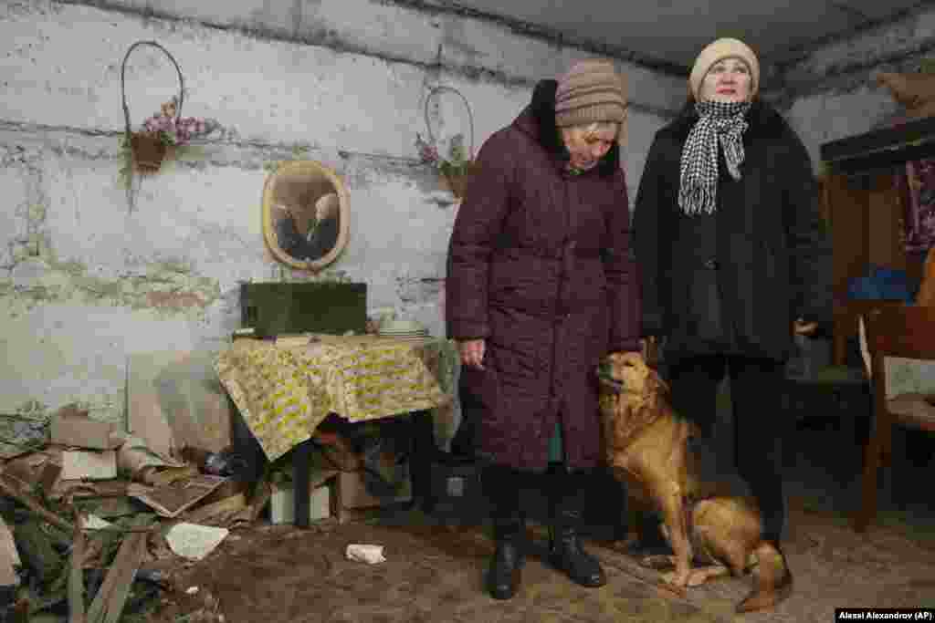 Lilia (majtas) dhe Tetyana, që të dyja banore të një fshati në periferi të Donetskut, flasin me një gazetar teksa qëndrojnë në një bodrum që përdoret për t&rsquo;u strehuar gjatë bombardimeve. Ato jetojnë në një zonë të kontrolluar nga separatistët që gjendet jo larg vijës së frontit të forcave qeveritare. Lilia dhe pesë persona të tjerë jetojnë në një banesë pesëkatëshe që nuk ka as ngrohje dhe as ujë. Shumë shtëpi në këtë rajon janë të braktisura, pasi u dëmtuan gjatë konfliktit më 2014-2015. &nbsp;