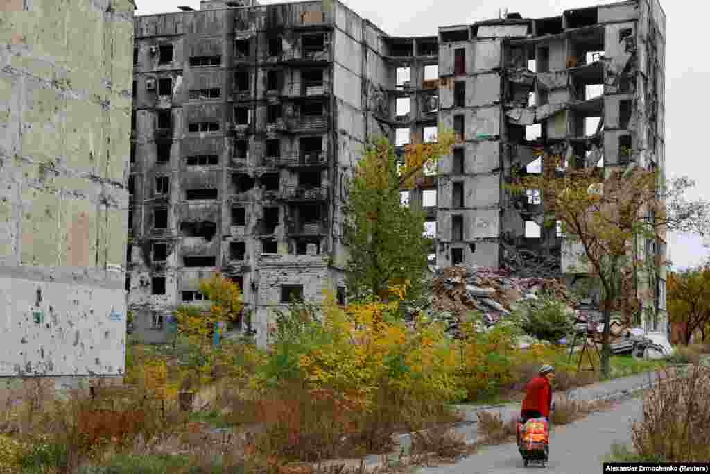 Жена поминува покрај руинирана станбена зграда на 29 октомври.