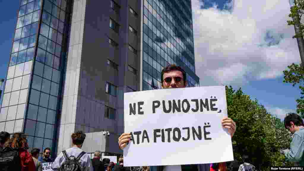"Ne punojmë ata fitojnë" shkruan në panon e këtij protestuesi që protestoi para ndërtesës së Qeverisë së Kosovës më 1 maj 2022.