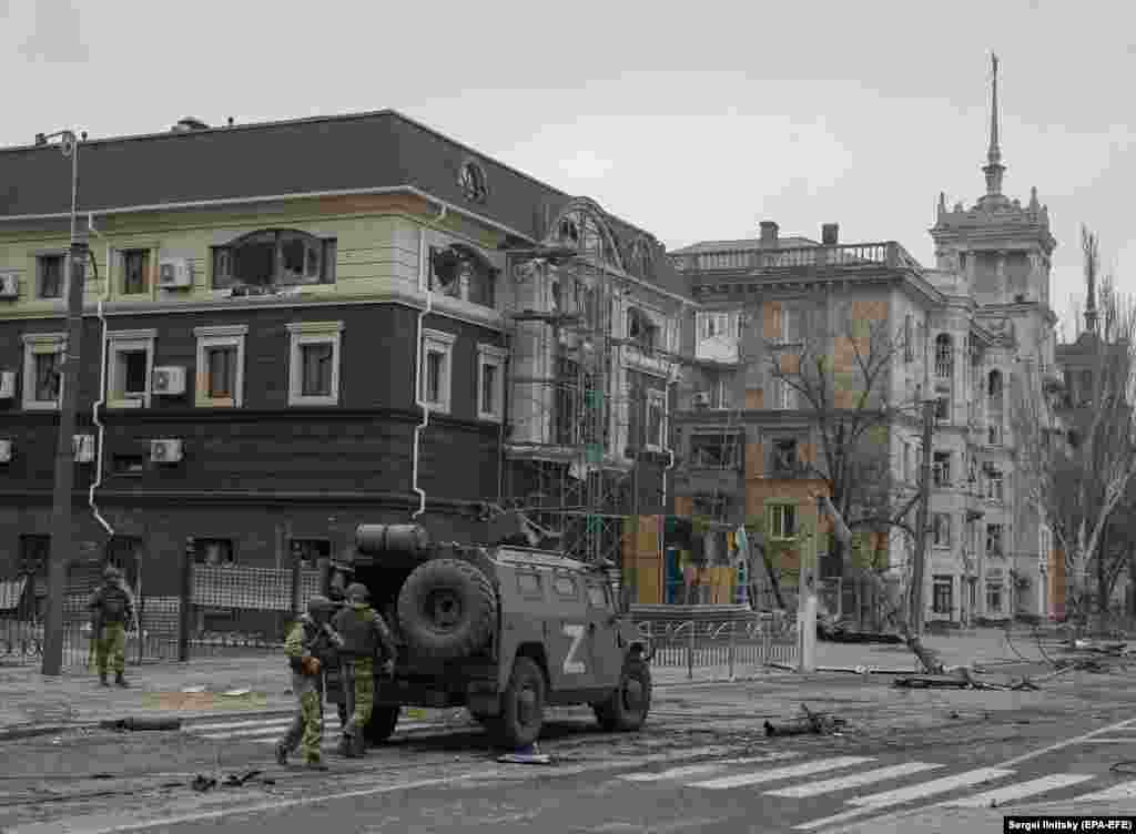 Trupat ruse shihen duke dalë nga një automjet i blinduar pranë "shtëpisë me majë" të epokës staliniste në prill të këtij viti.