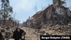 Një burrë struket mes rrënojave në lagjen Livoberezhnyi të Mariupolit të kontrolluar nga Rusia më 6 qershor.