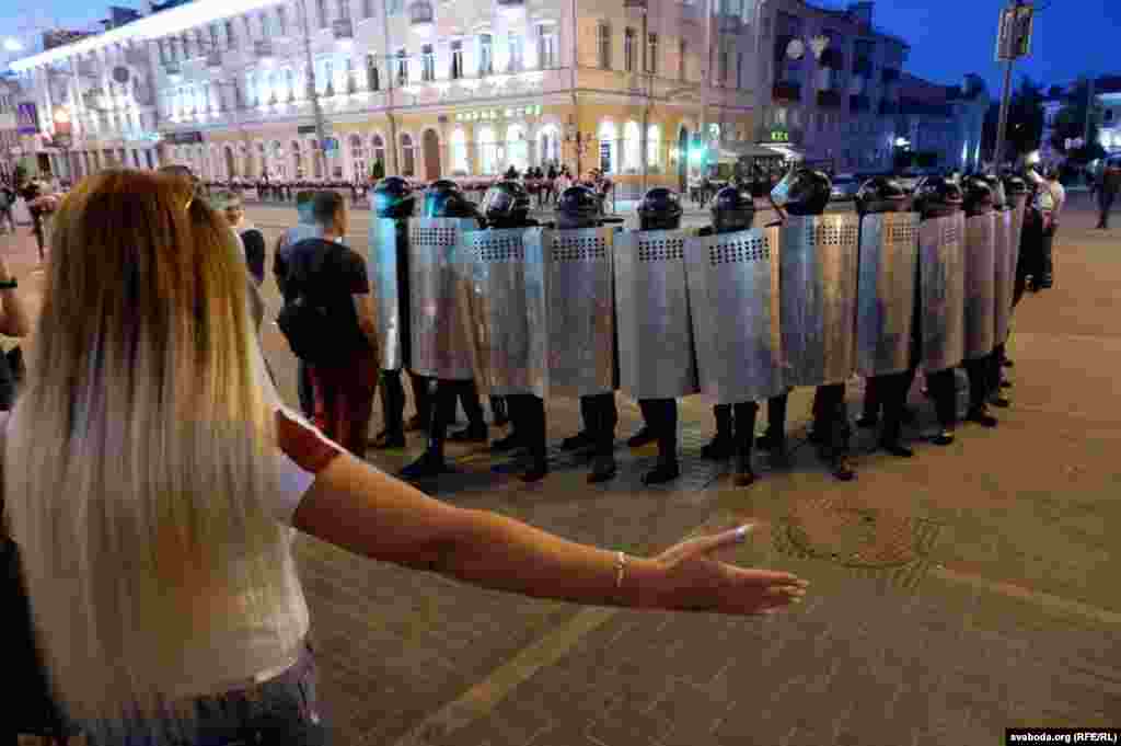 Žena širi ruke ka kordonu policije u gradu Homelu 10. avgusta.