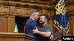 Președintele polonez Andrzej Duda îl îmbrățișează pe președintele ucrainean Volodimir Zelenski în timpul unei ședințe a parlamentului de la Kiev, pe 22 mai 2022.