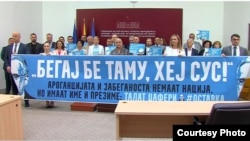 Пратениците на ВМРО-ДПМНЕ со транспаренти го дочекаат претседателто на Собранието Талат Џафери. 