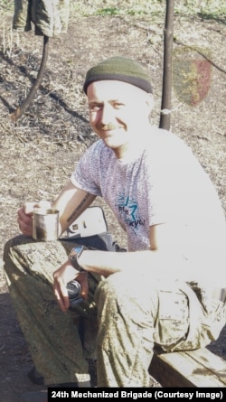A Russian soldier holding one of the lenses discovered with the Sony camera.