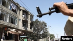 Luftëtarët talebanë qëndrojnë roje në vendin e sulmit në një tempull të Sikhëve në Kabul, më 18 qershor 2022.