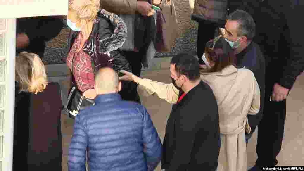 Građani, bez poštovanja fizičke distance, predaju zdravstvene knjižice na ulazu u COVID centar Doma zdravlja Podgorica.