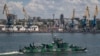  O navă a Marinei Ruse trece pe lângă portul maritim de marfă Mariupol, un oraș ucrainean ocupat de pe Marea Azov, în iunie 2022.