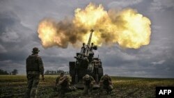 Ushtarë ukrainas duke gjuajtur një predhë. 