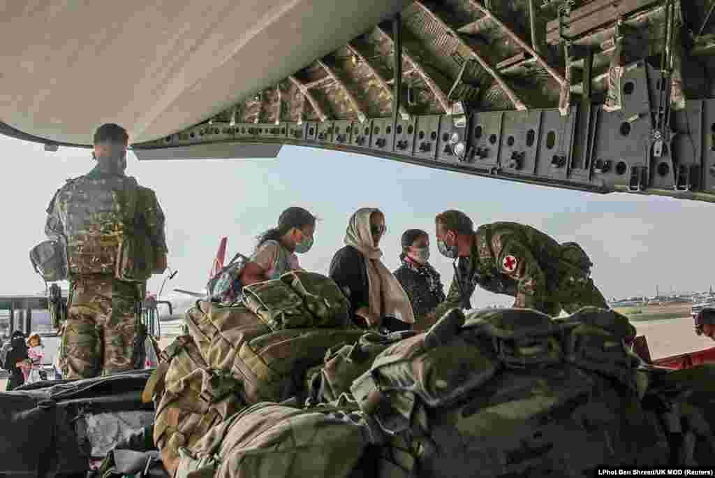 Британски државјани и лица со двојно државјанство се качуваат на воен авион за евакуација од аеродромот во Кабул.