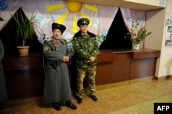 Pro-Russian militants stand guard at a polling station in Novoazovsk, in the eastern Donetsk region, on November 2.