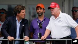 Tucker Carlson (b), ifj. Donald Trump és Donald Trump, az Egyesült Államok volt elnöke egy golftornán New Jersey államban 2022. július 31-én