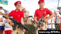 Doi băieți din Yunarmia cu arme în mâini la un eveniment în Sevastopol, în peninsula Crimeea ocupată de Rusia, august 2019.