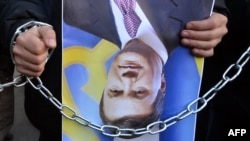 Демонстрант носи превртен портрет на претседателот Јанукович.