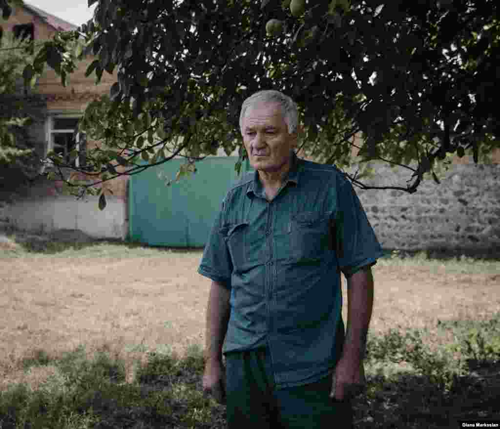 &quot;I feel like she is still with us,&quot; says Ruslan Kokov, 63. Ruslan was at the market when Oksana walked across the road to school, never to return. On her birthday, Ruslan and his son, Uruzmag, 27, always lay a place for her at dinner. They eat the foods she liked: melon, persimmons, blood oranges. Ruslan is pictured here standing in front of his house on Komintern Street. School No. 1 is clearly visible from his front room. Russian special forces were staked out there during the siege; during the final gun battle, bullets shattered his two front window panes. Ten years later, Ruslan hasn&#39;t gotten around to fixing them. &quot;When I come across something that reminds me of the tragedy, it just upsets me unnecessarily,&quot; he says. 