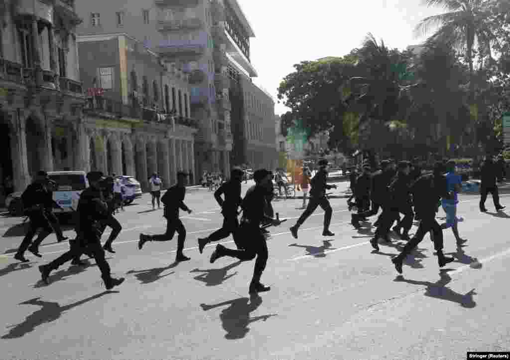 Policët vrapojnë gjatë protestave kundër qeverisë, në Havanë.