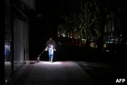 Vigo, Spania, 28 aprilie. O femeie își luminează drumul cu lanterna telefonului.