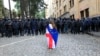 Demonstrantkinja ogrnuta gruzijskom i zastavom EU ispred kordona policije koji blokira pristup zgradi parlamenta tokom protesta u Tbilisiju, 14. maj 2024.