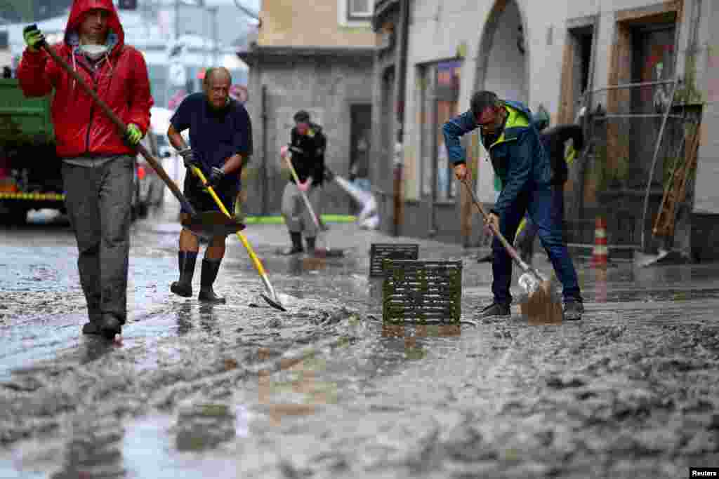 Ljudi uklanjaju blato nakon poplave u centru grada Hallein, Austrija, 18. jula 2021.